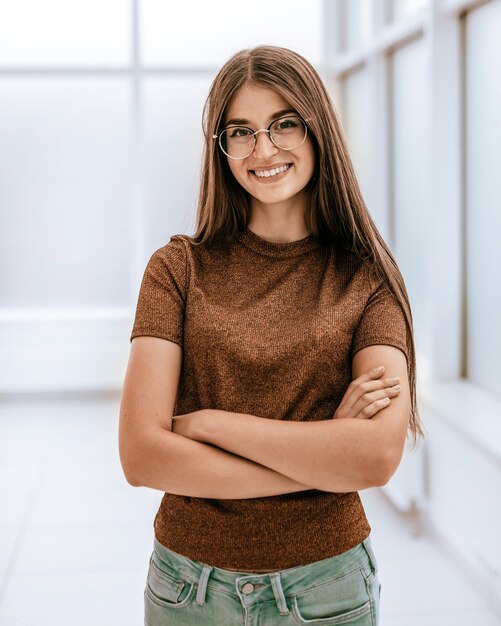 Sorridente giovane donna in piedi in ufficio luminoso