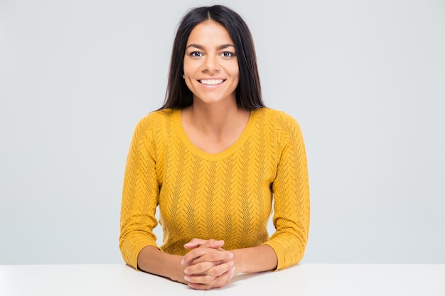 Sorridente giovane donna seduta al tavolo