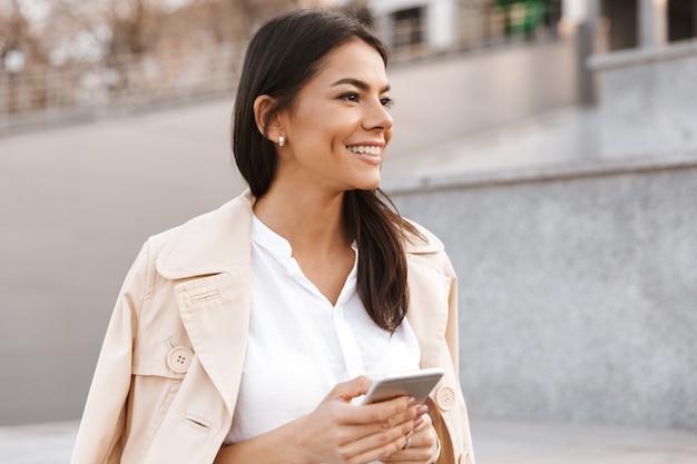 Sorridente giovane donna utilizzando il telefono cellulare