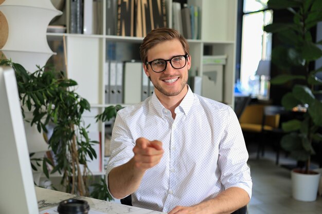 Sorridente giovane uomo d'affari con videochiamata in ufficio.