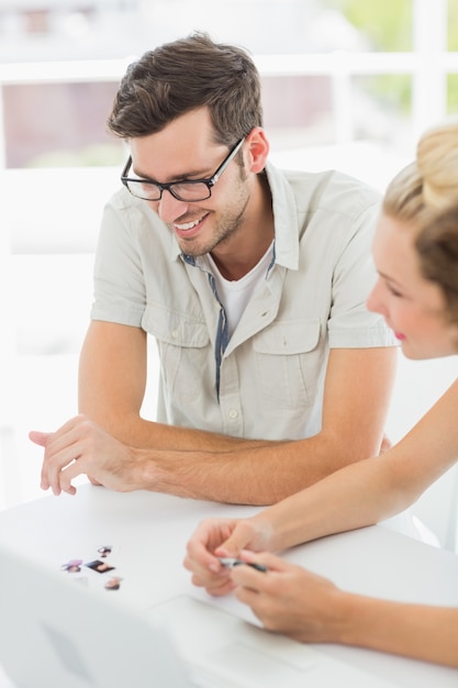 Sorridente giovane uomo e donna che lavorano alla scrivania