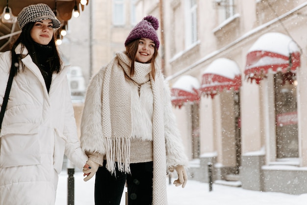 Sorridente giovani donne che indossano abiti invernali caldi in chat