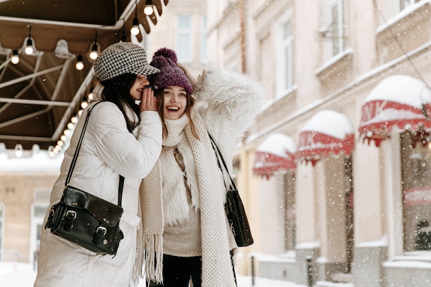 Sorridente giovani donne che indossano abiti invernali caldi in chat