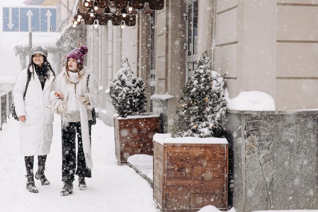 Sorridente giovani donne che indossano abiti invernali caldi in chat