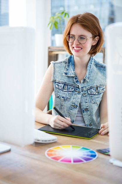 sorridente imprenditrice hipster disegno aat la sua scrivania