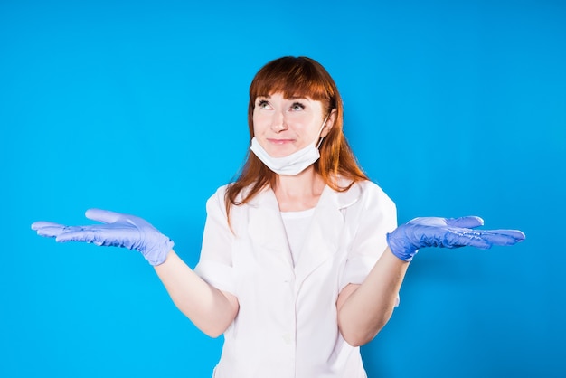 Sorridente infermiera dai capelli rossi con i guanti le braccia le braccia