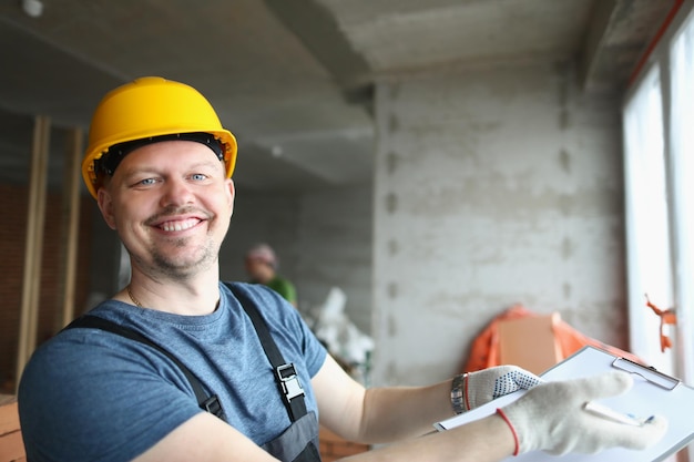 Sorridente lavoratore professionista tenere appunti con documento sull'acquisto della casa