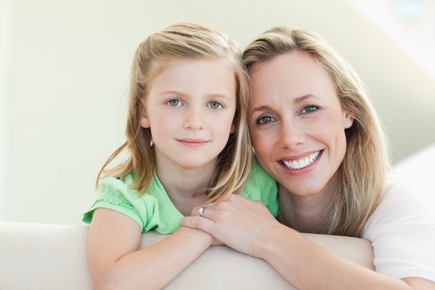 Sorridente madre e figlia sul divano