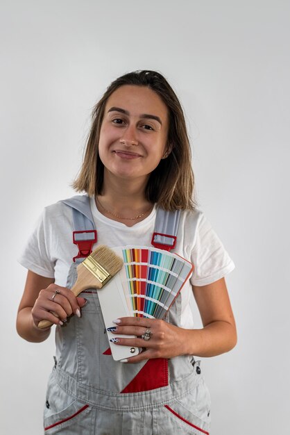 Sorridente operaio edile femminile in cappello duro che guarda macchina fotografica con felice espressione sul viso