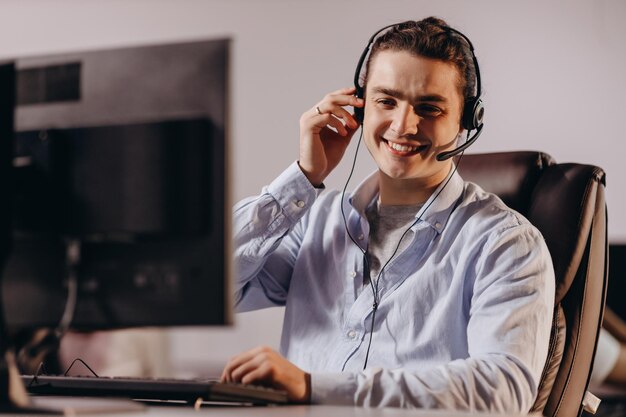 Sorridente operatore di call center che si gode il suo lavoro Allegro agente di assistenza clienti in cuffia che consulta il cliente