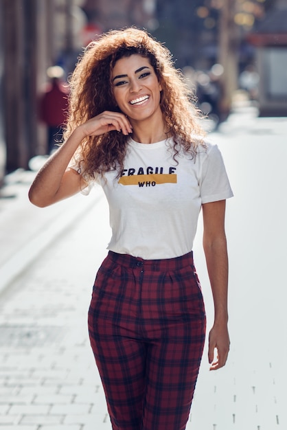 Sorridente ragazza araba in abiti casual in strada.