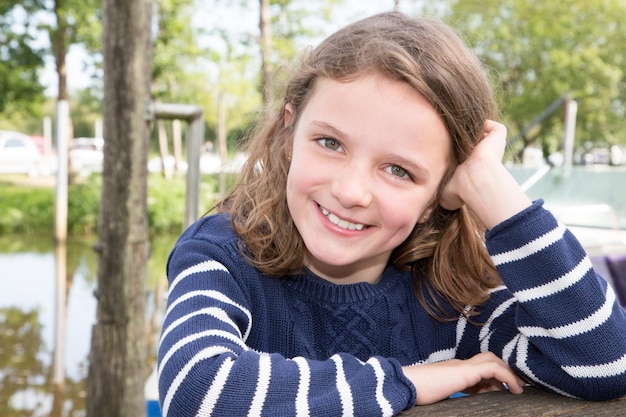 Sorridente ragazza carina all'aperto lungo il fiume