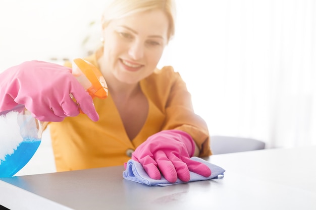 Sorridente ragazza degna con l'attrezzatura per la pulizia