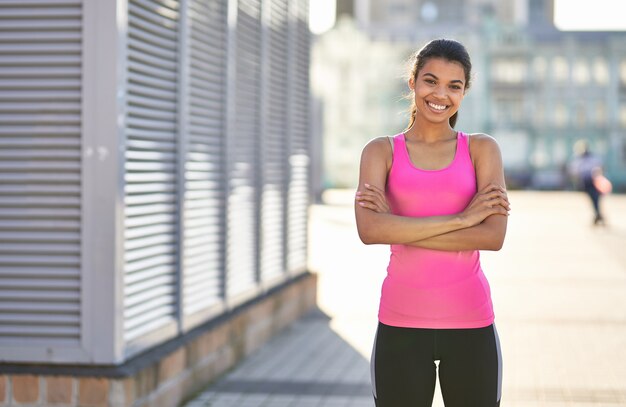 Sorridente signora afroamericana in maglietta sportiva brillante all'aperto