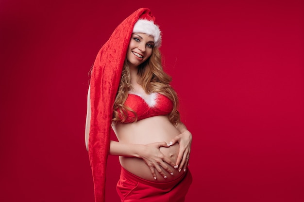 Sorridente signora incinta che tocca l'addome in studio