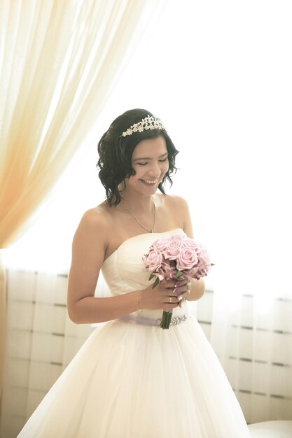 Sorridente sposa felice con un mazzo di rose