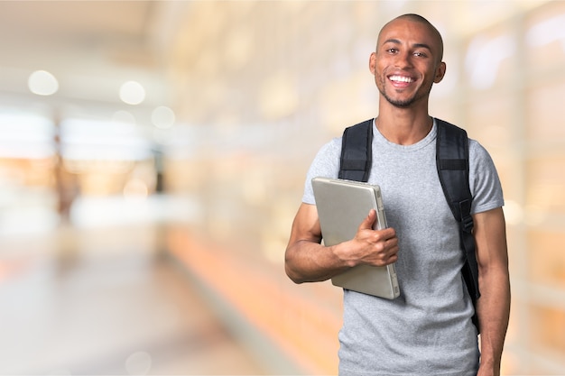 Sorridente studente africano con laptop