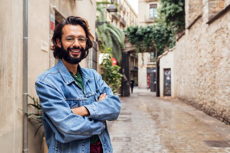 Sorridente uomo caucasico con le braccia incrociate in strada