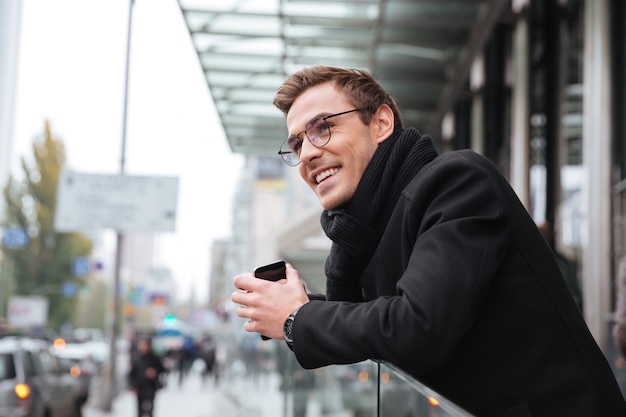 Sorridente uomo d'affari con gli occhiali vicino all'ufficio.