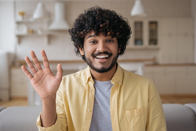 Sorridente uomo indiano freelance che ha una videochiamata che lavora online da casa Influencer che registra video