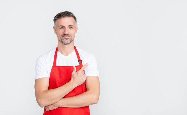 Sorridente uomo maturo cameriere in grembiule su sfondo bianco