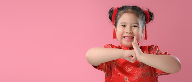 Sorridenti bambine asiatiche carine in abito tradizionale cinese rosso. Concetto di felice anno nuovo cinese.