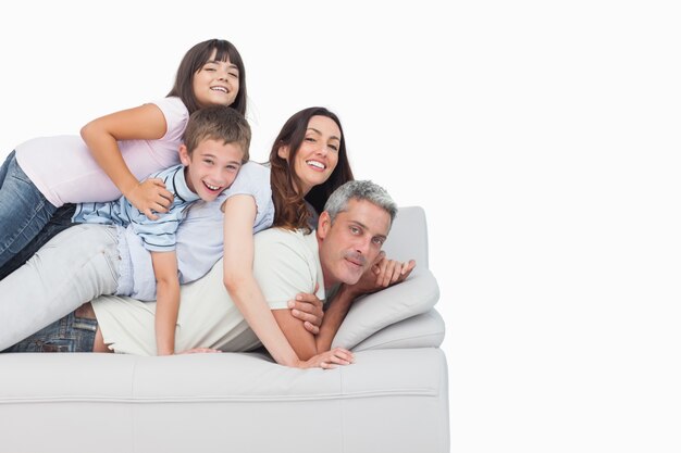 Sorridenti bambini che si trovano sui loro genitori sul divano