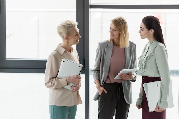 sorridenti belle donne d'affari che parlano in ufficio