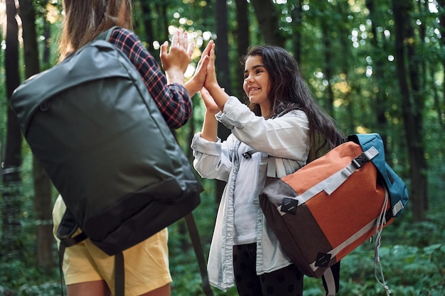 Sorridenti e si divertono Due ragazze sono nella foresta a svolgere un'attività di svago alla scoperta di nuovi posti