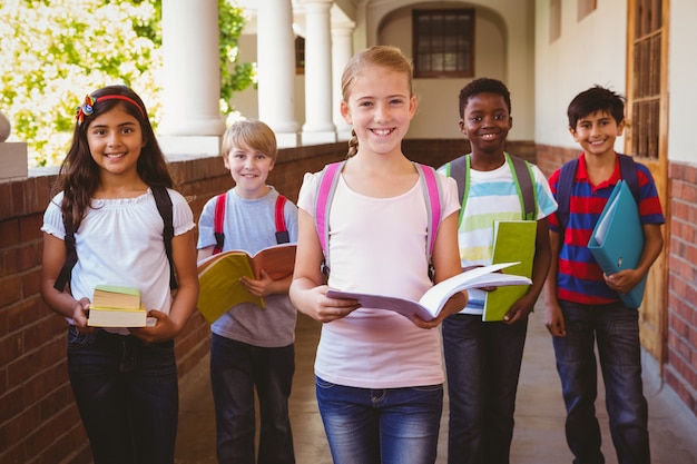 Sorridenti piccoli bambini della scuola nel corridoio della scuola