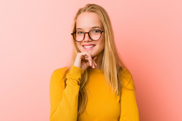 Sorridere adorabile della donna dell'adolescente felice e sicuro, mento commovente con la mano.