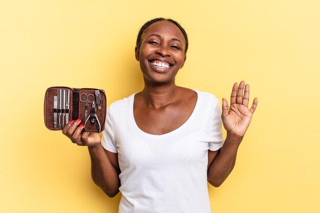 Sorridere allegramente e allegramente, agitare la mano, darti il benvenuto e salutarti o salutarti. concetto di strumenti per unghie