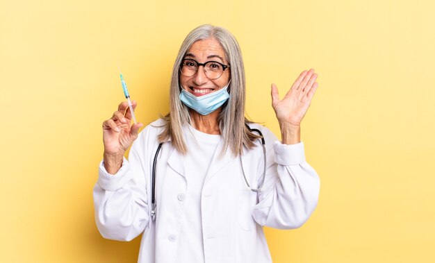 Sorridere allegramente e allegramente, agitare la mano, darti il benvenuto e salutarti o salutarti. medico e concetto di vaccino