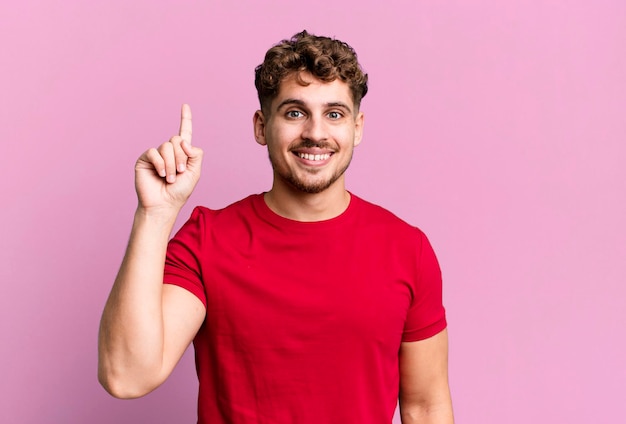 Sorridere allegramente e felicemente verso l'alto con una mano per copiare lo spazio