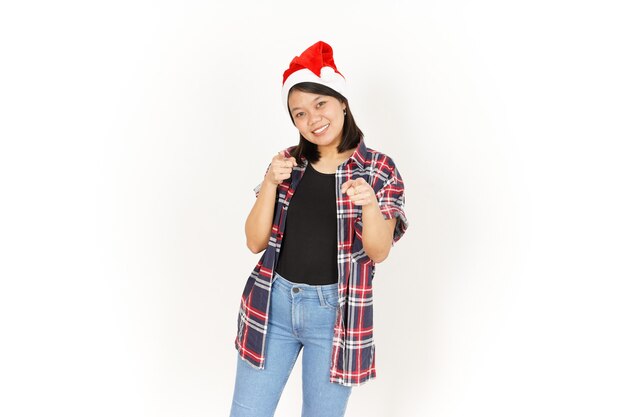 Sorridere e indicarti una bella donna asiatica che indossa una camicia scozzese rossa e un cappello da Babbo Natale