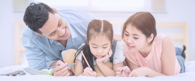 Sorridere felice della famiglia asiatica e rilassarsi sul letto a casa.