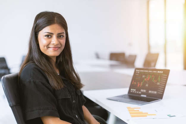 Sorridere felice fiducioso del capo del ritratto della donna di affari dell'India di giovane successo in ufficio