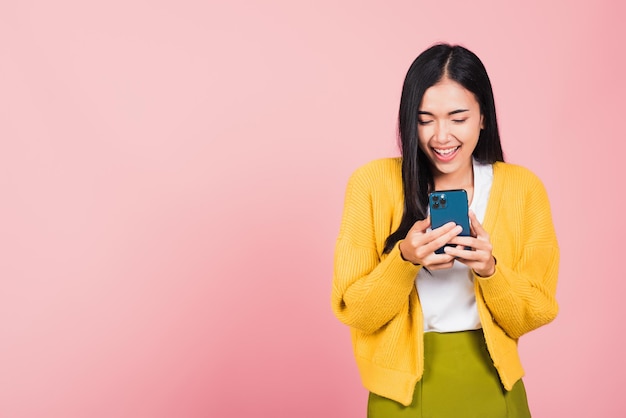 Sorridere teenager della donna eccitato facendo uso del telefono cellulare astuto