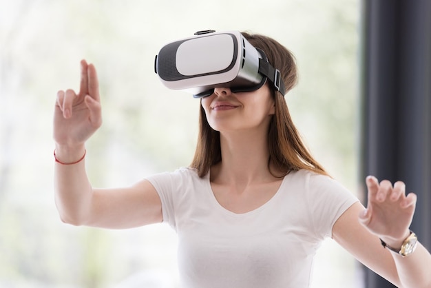 Sorridi donna felice che fa esperienza con gli occhiali VR-headset della realtà virtuale a casa