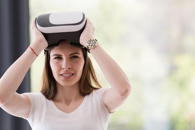 Sorridi donna felice che fa esperienza con gli occhiali VR-headset della realtà virtuale a casa