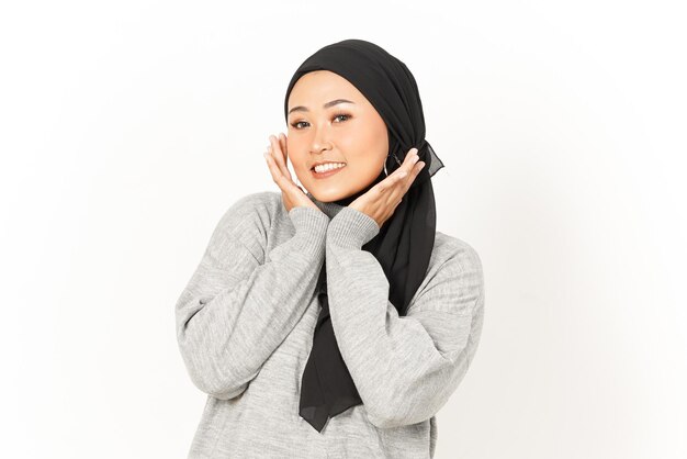 Sorridi e guarda la telecamera della bella donna asiatica che indossa l'hijab isolata su sfondo bianco