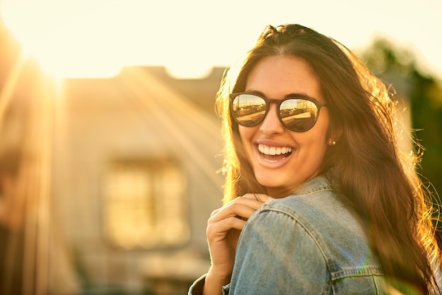 Sorrisi ispirati all'estate Ritratto di una giovane donna felice e attraente all'aperto