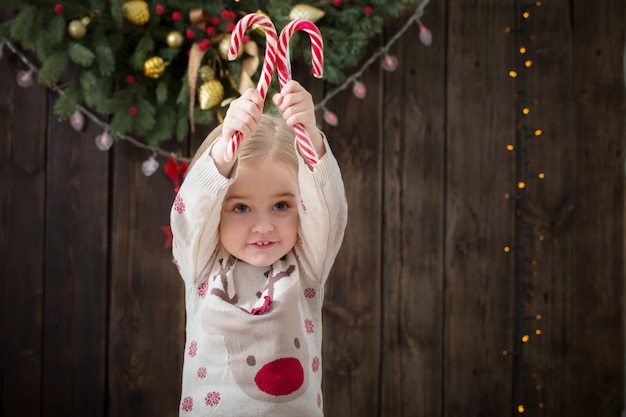 Sorriso bambina con decorazioni natalizie su legno scuro