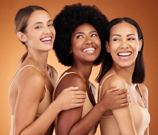 Sorriso di gruppo di donne felici di bellezza e cura della pelle insieme a una pelle sana e luminosa e pulita Ragazze modello cosmetiche diverse e naturali che sorridono con soddisfazione su sfondo marrone studio