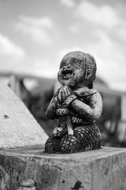 Sorriso di pietra rotta in bianco e nero e statua di bambino felice