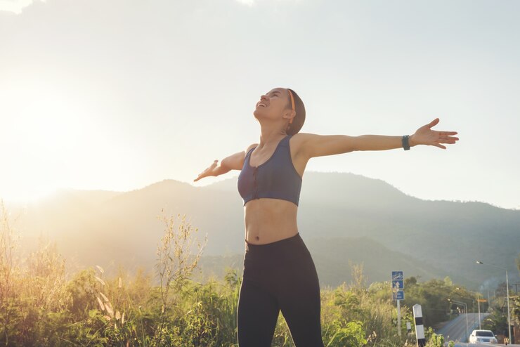 Sorriso di rilassamento felice della giovane donna di bellezza con il panno blu della barra di sport dopo l'esecuzione