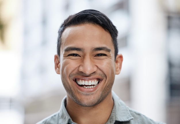 Sorriso felice e ritratto del viso di un uomo con una mentalità visionaria e motivazione per il successo Giovane imprenditore o uomo d'affari professionale aziendale che sorride nella felicità sullo sfondo della strada cittadina