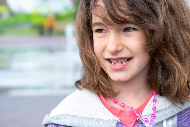 Sorriso felice senza denti di una ragazza con un dente di latte inferiore caduto in primo piano Cambiando denti in molari nell'infanzia