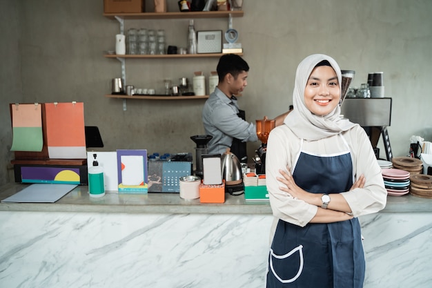 Sorriso femminile cameriera con le mani incrociate