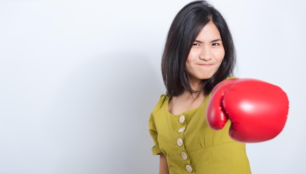 Sorriso in piedi della giovane donna in guantoni da boxe